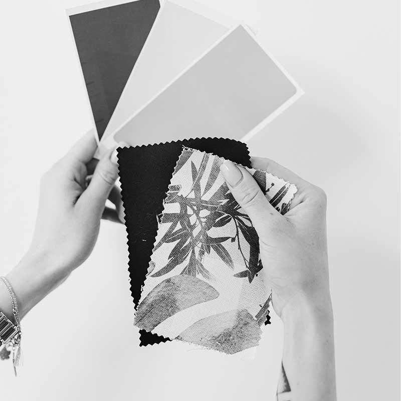 Image en noir et blanc représentant une personne tenant dans sa main un échantillon de couleurs et de pattern