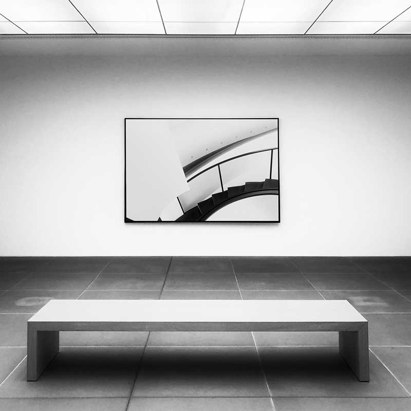 photo en noir et blanc montrant une salle de musée au décors minimaliste